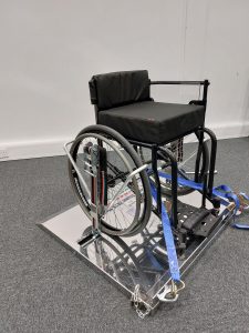 An RMA sport fencing wheelchair set up on a single piece of fencing frame, the image shows how to clamp the chiar effectively and is currently set up for classification purposes.