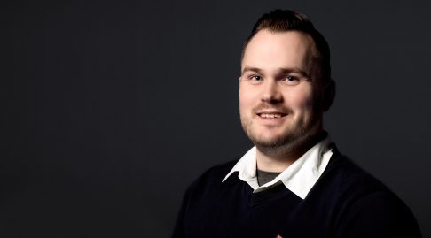 An image of Rick smiling to the camera wearing smart clothing and a British Fencing logo pin.